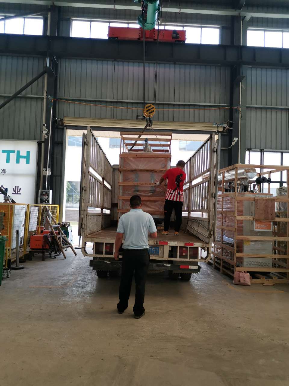 黄瓜成视频人APP的工作人员正在吊装医院用72kw电蒸汽发生器上车